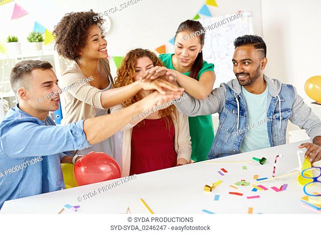 happy business team at office party holding hands