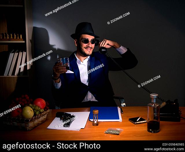 The detective sitting in dark room in vintage concept