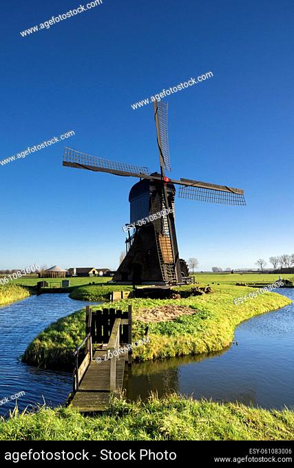 Bridge to the Noordeveldse windmill near the Dutch village Dussen with a clear blue sky in the background
