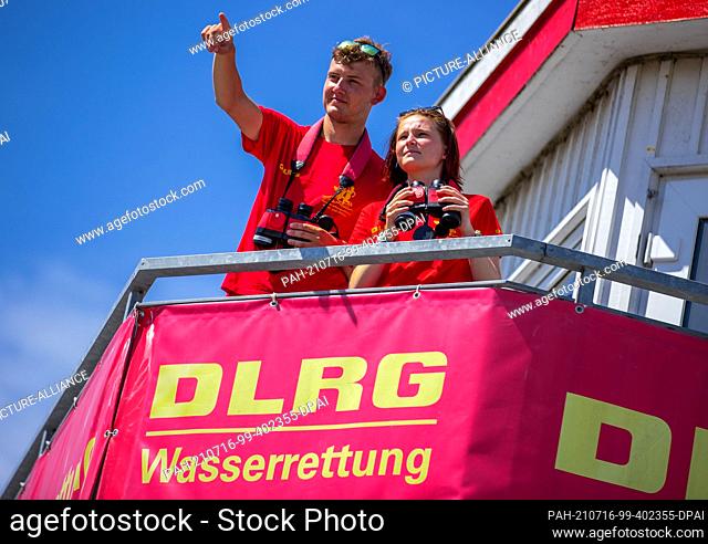 15 July 2021, Mecklenburg-Western Pomerania, Prerow: Lifeguards Nils Frechen and Olivia Fischer watch bathers on the beach and in the Baltic Sea from the main...