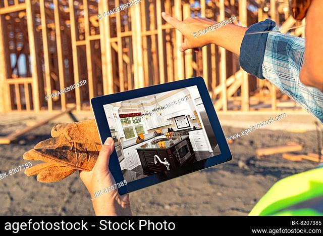 Female construction worker reviewing kitchen on computer pad at construction site