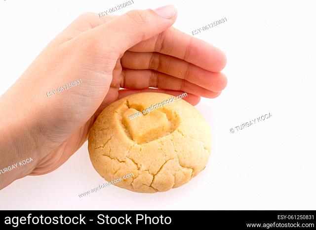 Hand holding a Light brown cookie with a pattern on a white background