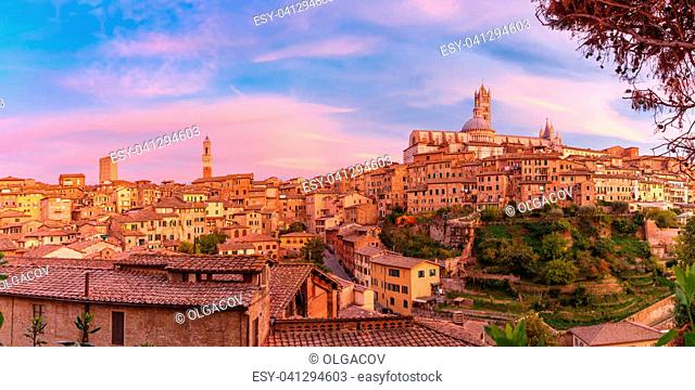 Beautiful panoramic view of Old Town with Dome and campanile of Siena Cathedral, Duomo di Siena, and Mangia Tower or Torre del Mangia at gorgeous sunset, Siena