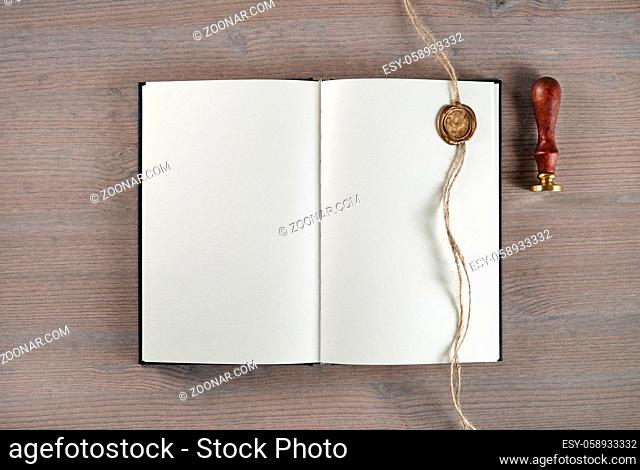 Vintage blank book, sealing wax, stamp and rope on wooden background. Flat lay