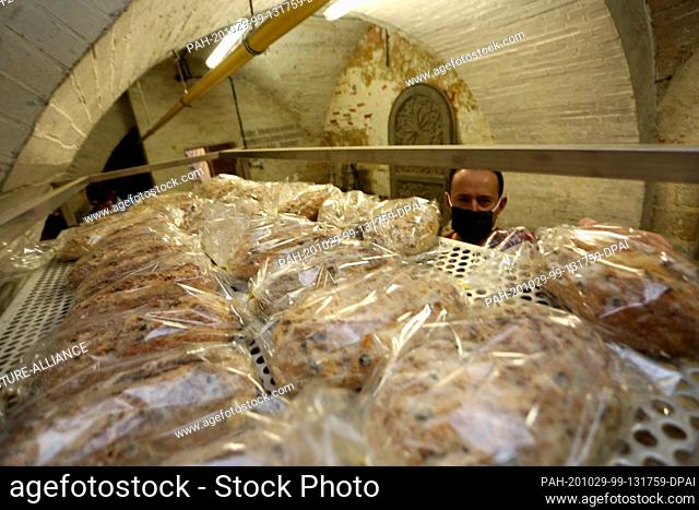 29 October 2020, Saxony-Anhalt, Halberstadt: Mathias Hlady, baker at the Halberstadt bakers and confectioners, sorts fresh stollen into the cathedral's reminder...