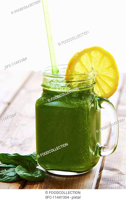A green smoothie with a slice of lemon