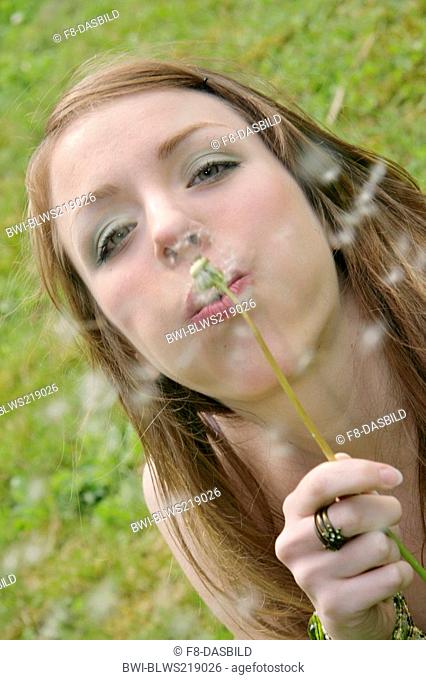 young woman blows a blowball
