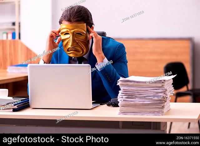 Young employee wearing sad mask in the office