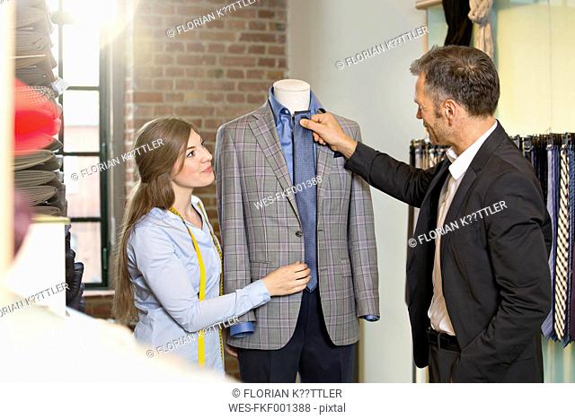 Young seamstress discussing jacket with customer