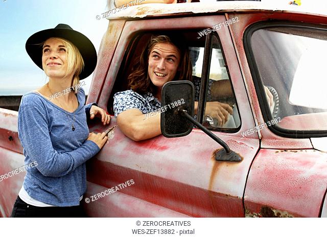 Smiling young couple with an old pick up