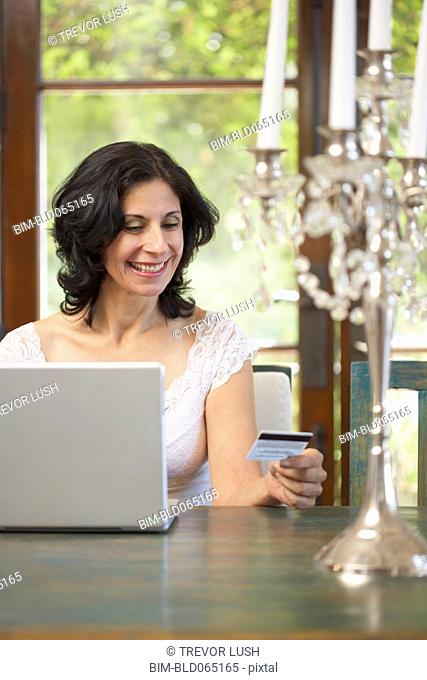 Confident Middle Eastern woman shopping online with credit card
