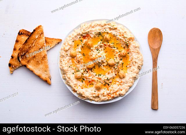 home made hummus in bowl on white table