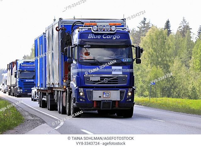 Uurainen, Finland. June 7, 2019. Blue Volvo FH16 truck of Blue Cargo Oy pulls portable cabins on trailer in highway traffic with another lorry