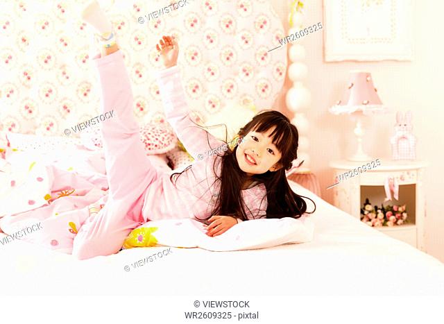 Cute little girl playing on the bed