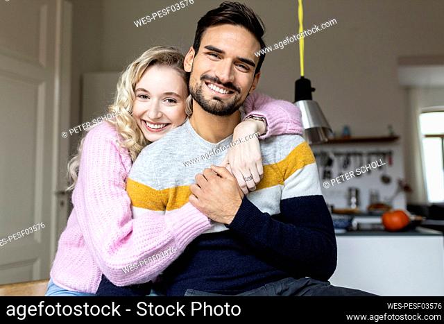 Happy woman embracing man at home