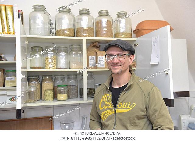 13 November 2018, Hessen, Friedberg: Andreas Arnold stands in the kitchen of his apartment in front of a cupboard in which glasses with food are placed
