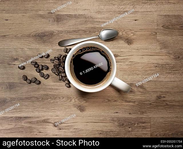 Coffee Mug with spoon and coffee bean on Wooden Table