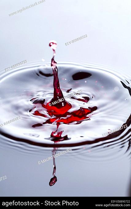 Close view of a droplet of wine hitting a surface of wine