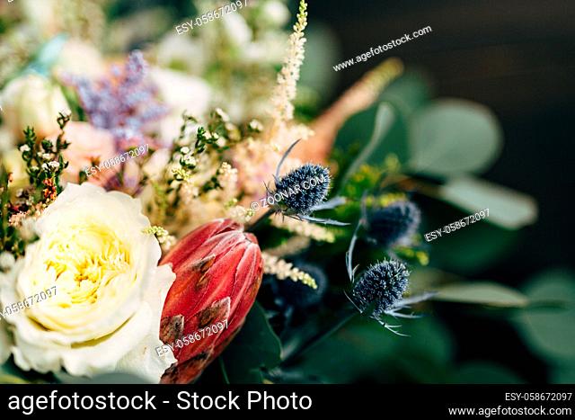 bridal bouquet of white roses, branches of eucalyptus tree, protea and eryngium. High quality photo