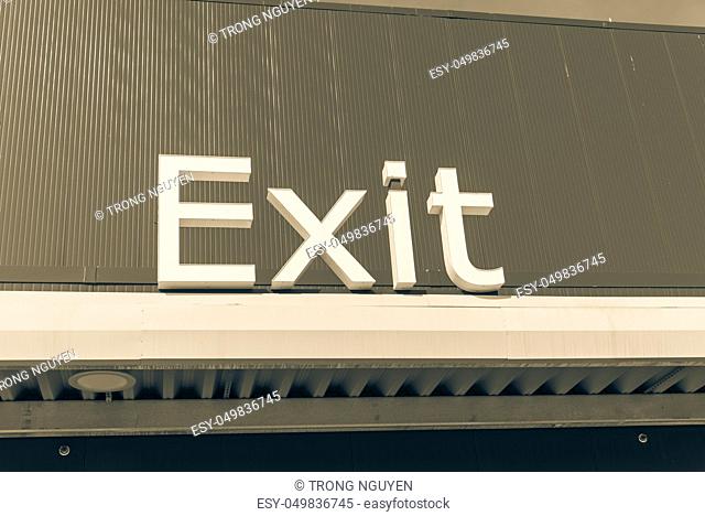 Vintage tone close-up of outdoor exit sign on building facade