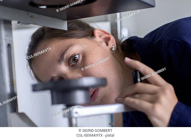 Close up of female engineer looking at valve in factory