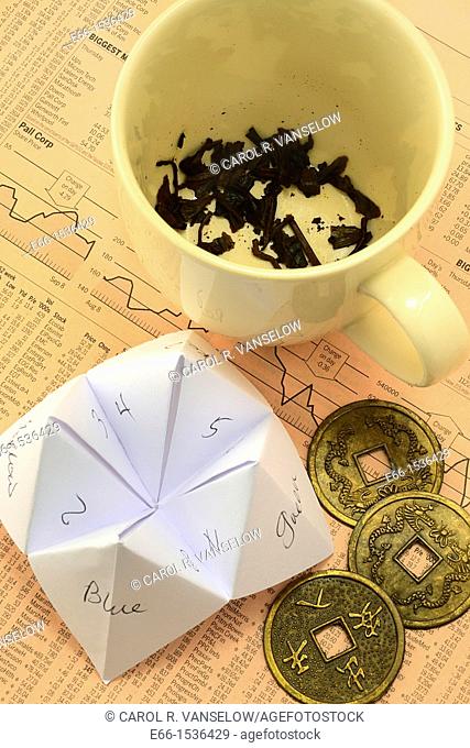 Where not to go for investment advice: Tea cup with tea leaves, Origami fortune teller - cootie catcher, Coins used with I-Ching laying on European financial...