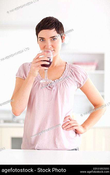 Woman drinking a glass of wine looking into the camera