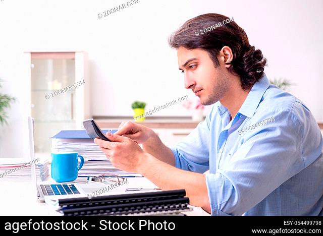 The young male employee working at home