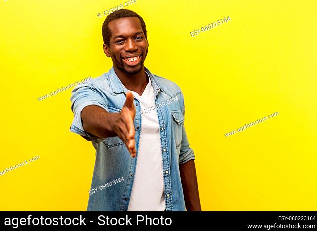 Portrait of friendly cheerful charismatic man in denim casual shirt with rolled up sleeves giving hand to handshake, getting to know new people, meeting