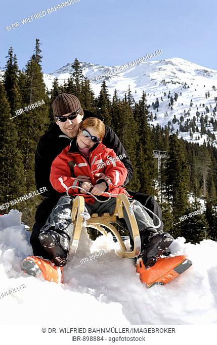 Father and daughter riding a sledge