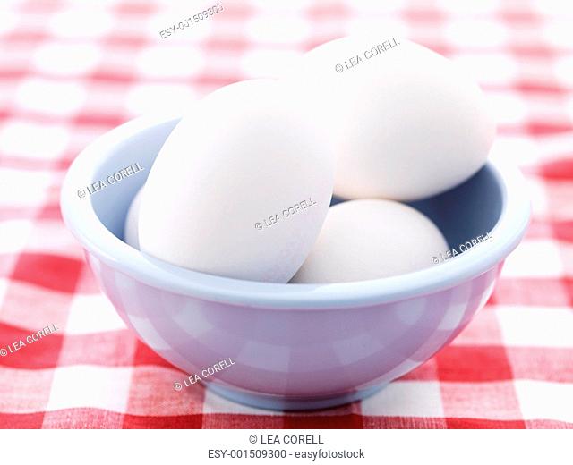Farm eggs in a creamic bowl on dining table