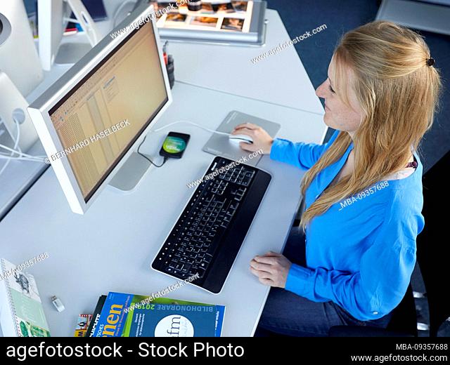 Young woman working at desk with computer