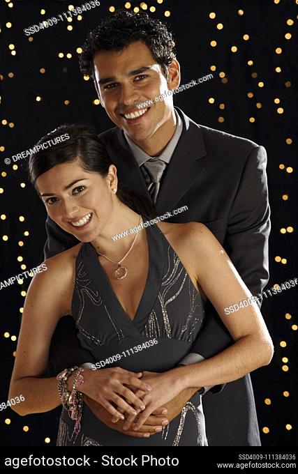 Hispanic couple dressed for night out with lights in background