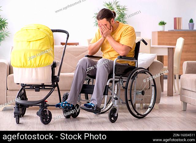 Young man in wheel-chair looking after newborn