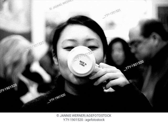 Chinese girl drinking from a mug marked 'Made in China'