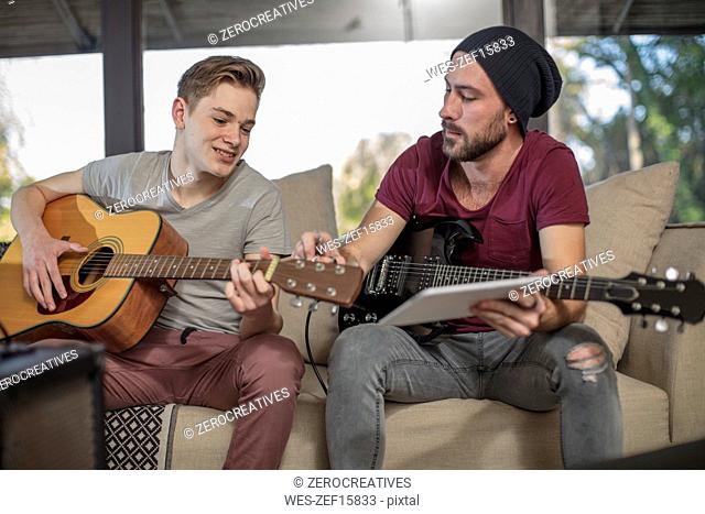Musician teaching student how to play guitar