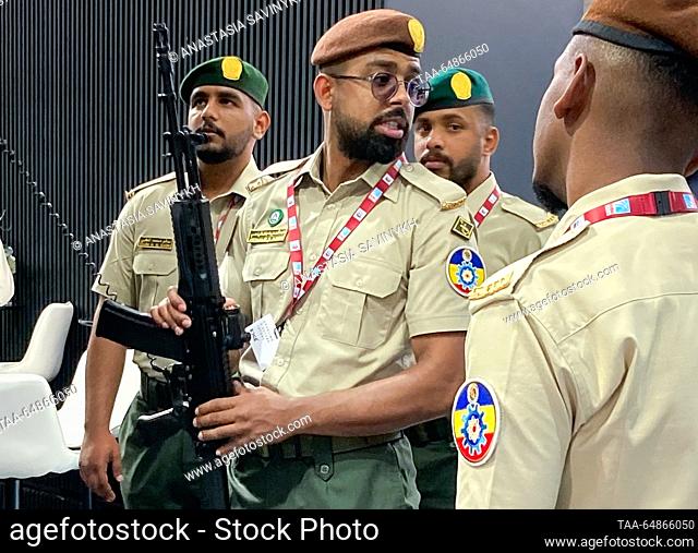 UNITED ARAB EMIRATES, DUBAI - NOVEMBER 15, 2023: Foreign military personnel inspect a Kalashnikov rifle at a Rostec stand is on display at the Dubai Airshow...
