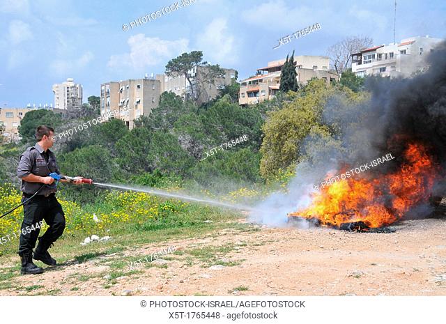 Fireman extinguishes a tire fire as part of a fire fighting drill