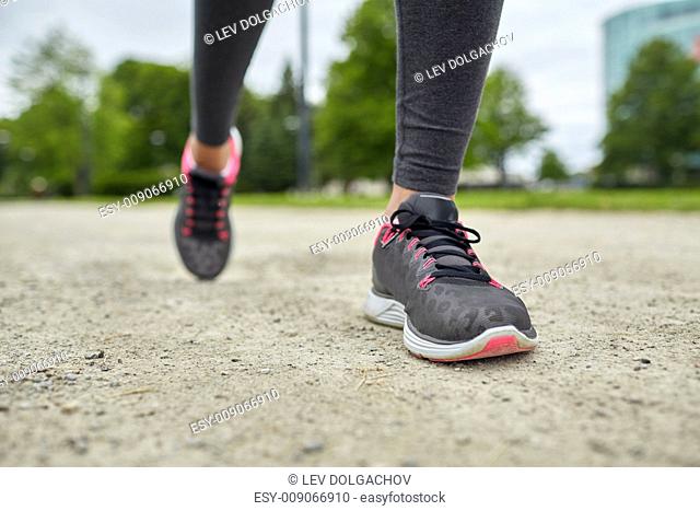 fitness, sport, training, people and lifestyle concept - close up of woman feet running on track from back