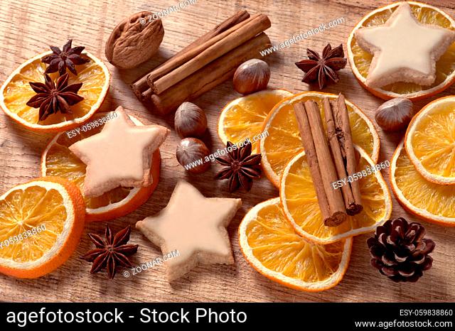 Weihnachtsmotiv mit getrockneten Orangenscheiben, Zimtstangen, Nüssen und Plätzchen