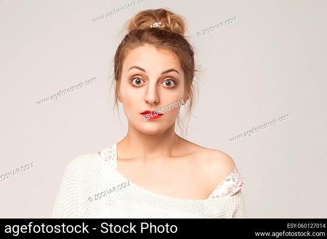 Portrait of blonde adult woman with surprised face. Studio shot, gray background