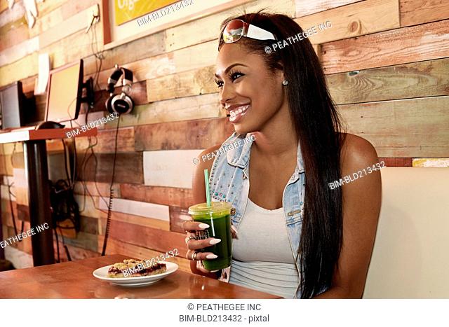 African American woman having juice in cafe