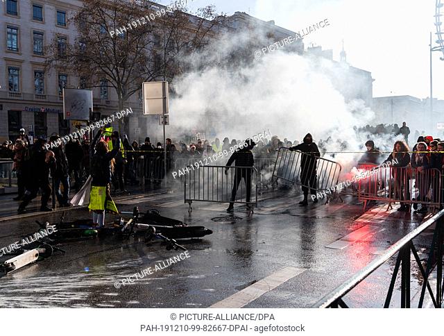 10 December 2019, France (France), Lyon: Demonstrators build a barricade during a demonstration in the context of strikes and protests against the pension...