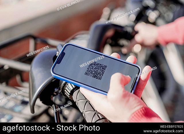 Man paying with smart phone at electric bicycle sharing system