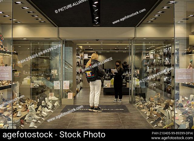 05 April 2021, Greece, Athen: A woman is registered before she can enter the shoe store. From Monday, 05.04.2021, shops in large parts of Greece will be allowed...