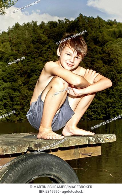Boy sitting on a jetty