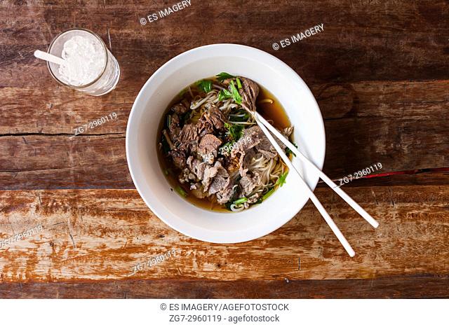 Thai beef noodle soup on a wooden table