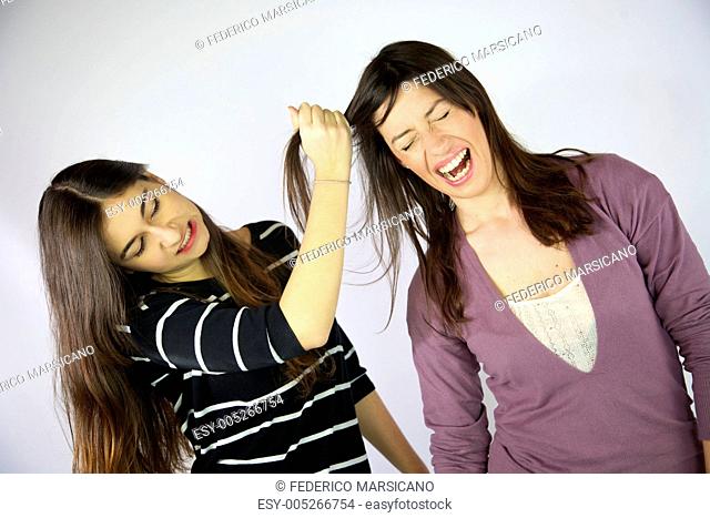 Girl pulling hard long hair of her friend
