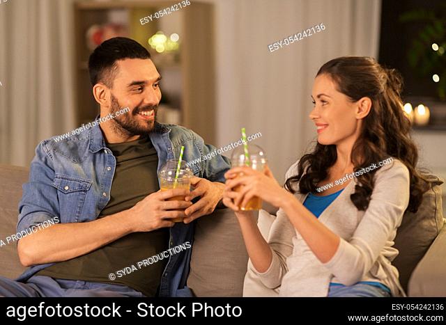 happy couple drinking takeaway juice at home