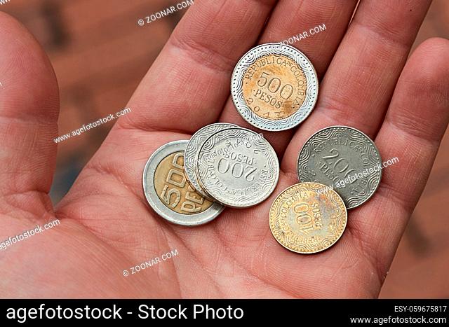 Coins in human hand, Colombian Pesos